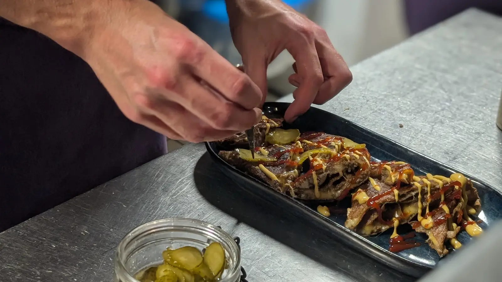 Mains qui dressent une assiette dans la cuisine de Mamilig