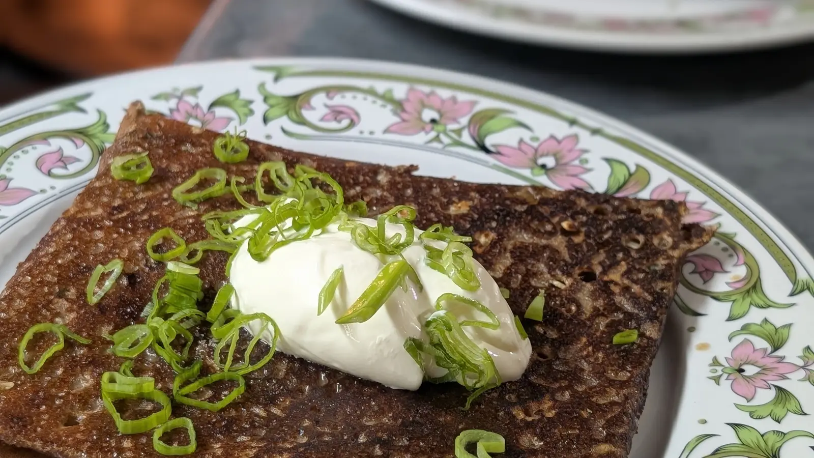 Galette de blé noir à la crème et à la ciboulette dans une assiette en faïence