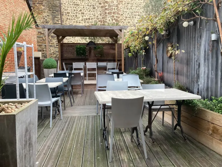 Terrasse en bois de la crêperie Mamilig à Châteaugiron, tables, chaises et grande table sous la pergola